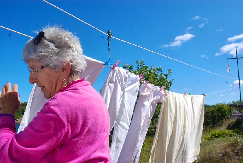 Doris Tucker hangs laundry out to dry Sept. 7 in Little Bay Islands.