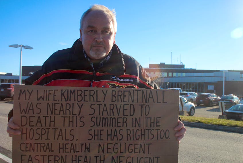 Ron Carter holds a sign outside of James Patton Memorial Regional Health Centre in Gander, trying to find answers about the treatment of his common law spouse Kim Brentnall. After being admitted following a stroke July 5, the Gambo man said Brentnall refused to eat and it took six weeks and a trip to St. John’s to address her starvation.