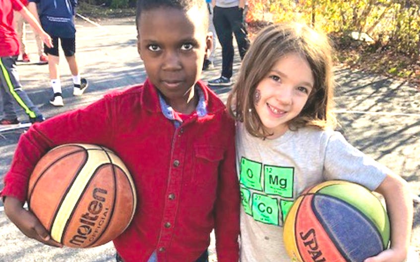 The new basketball court will provide countless hours of fun for children - like these two young athletes who attended the unveiling of the court on October 28.