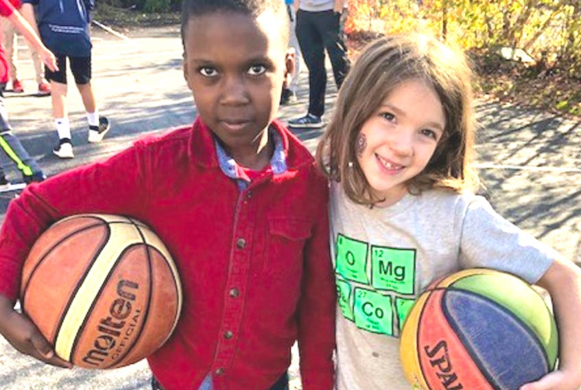 The new basketball court will provide countless hours of fun for children - like these two young athletes who attended the unveiling of the court on October 28.