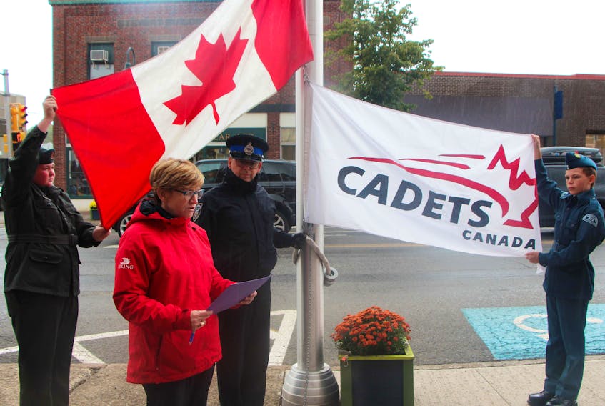 Army cadet Tucker Doiron (left) and air cadet Samuel Falsnes hold wide and straight the Canadian and cadet flags, prior to the raising of both, during a ceremony Oct. 4 outside of Antigonish town hall. While the cadets performed their duty, Mayor Laurie Boucher read a proclamation recognizing Oct. 5 as Cadet Day across the province, and bylaw enforcement officer John Pellerin waited to perform the raising operation.
