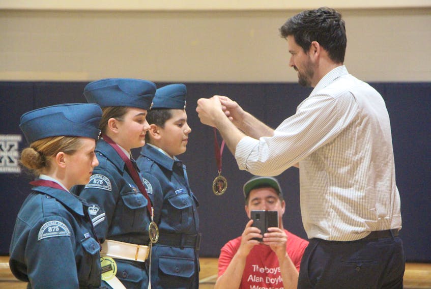 Central Nova MP Sean Fraser presenting Melanie Collins, Sarah Penney and Ben Polson of the 875 Antigonish Lions Air Cadet Squadron medals for 100 per cent perfect attendance during the year-end parade and ceremonial review on June 7.