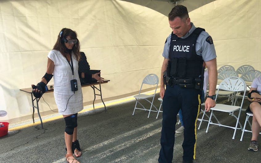 As part of Ford Motor Company’s Driving Skills for Life program, participants try on the innovative Drugged Driving Suit which simulates the physical impact of impairment on driving and walking. Here, officer Morrison of the Halifax Regional Police demonstrates walking in a straight line, a roadside test to check for impairment. -