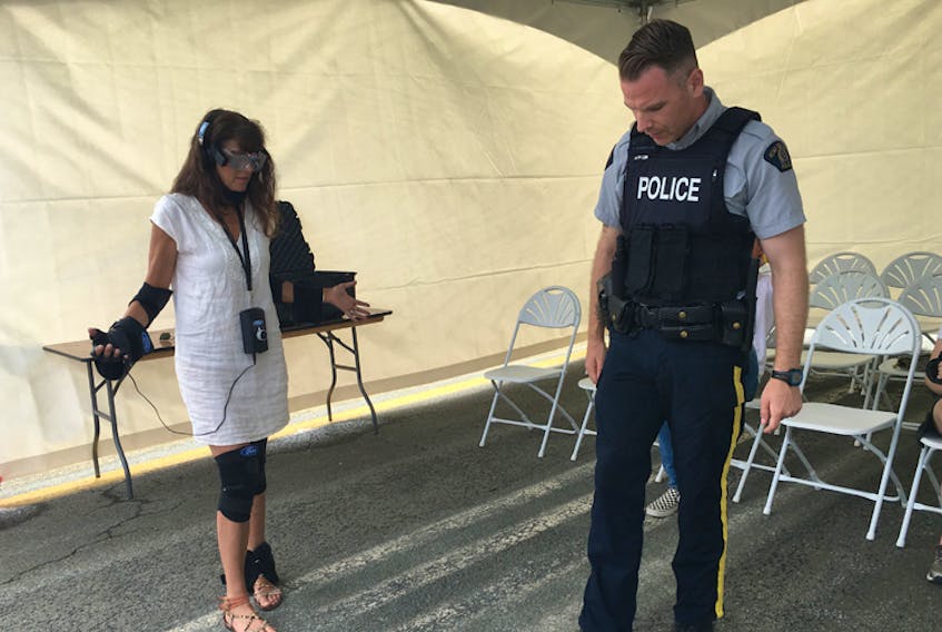 As part of Ford Motor Company’s Driving Skills for Life program, participants try on the innovative Drugged Driving Suit which simulates the physical impact of impairment on driving and walking. Here, officer Morrison of the Halifax Regional Police demonstrates walking in a straight line, a roadside test to check for impairment. -