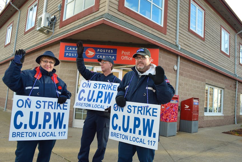 Members of the Canadian Union of Postal Workers Breton Local 117 including, from left, Mae James, a part time postal clerk, Morgan Fudge, a full-time retail postal clerk and Joe Reno, a part time postal clerk, picket in front of the Canada Post building in Sydney on Thursday. Members of CUPW are without a contract and have been holding rotating strikes across the country.