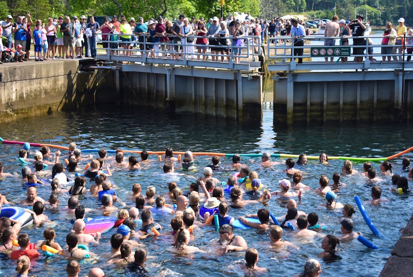 Participants of St. Peter's Swim the Canal event watch as the lock gates open on the Atlantic Ocean side of the historic waterway. More than 350 swimmers took part in the annual event that this year marked the 150th anniversary of the St. Peter's Canal. (KELLY GOULD PHOTO)