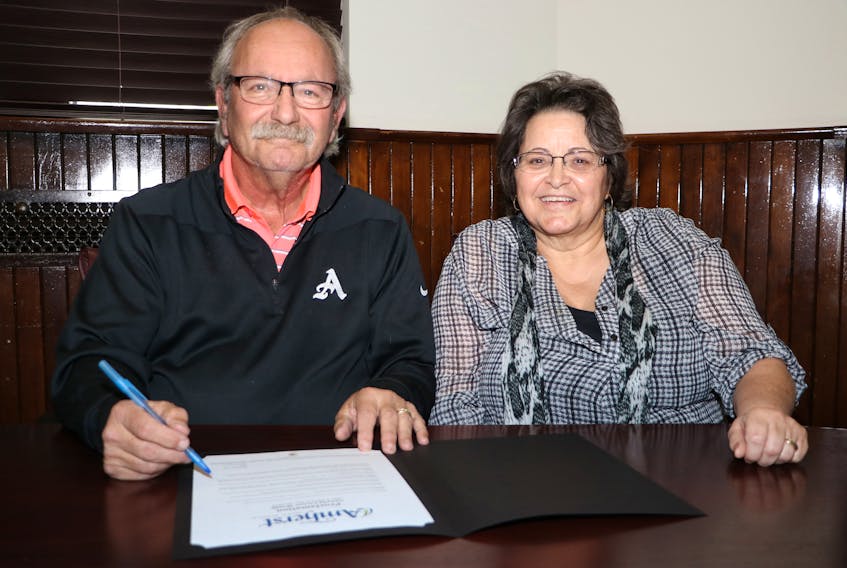 Bernice Vance, operations manager at Nova Scotia Works-CANSA, watches as Mayor David Kogon signs a proclamation declaring November as Canada Career Month in Amherst. Tom McCoag/Town of Amherst photo