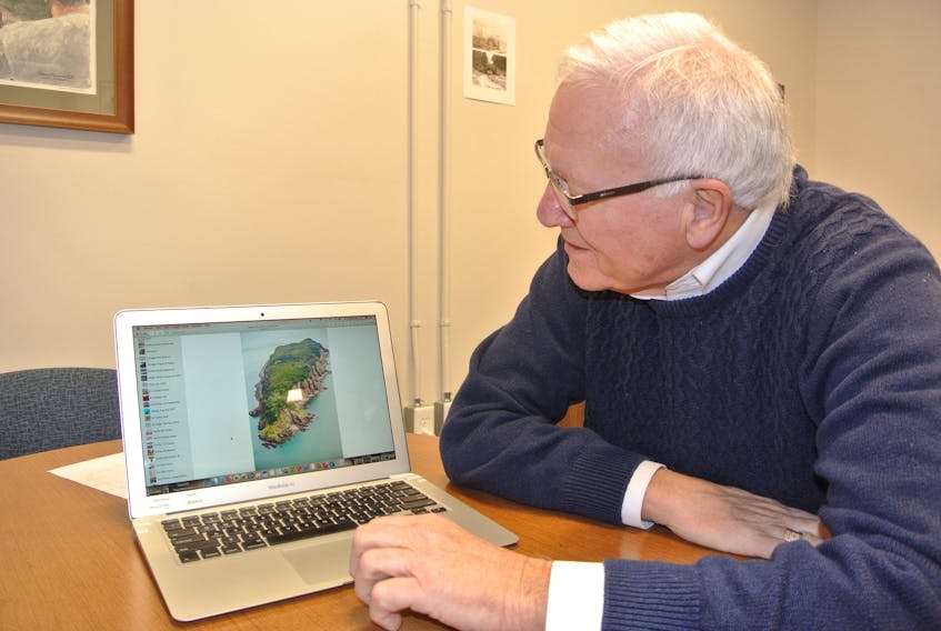 Cumberland-Colchester MP Bill Casey looks over photos of Isle Haute on his computer. The longtime MP hopes to see some added protection for the island off Advocate Harbour sometime in 2019.