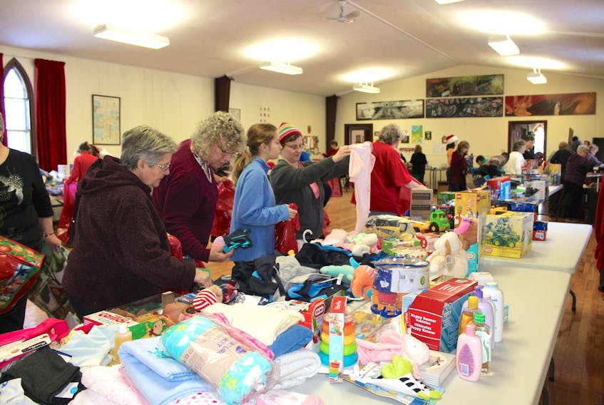 Volunteers sort and bag donations during last year’s Christmas Cheer program packing day.