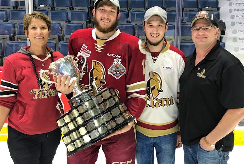 Cole Rafuse, second from left, holding the Memorial Cup with his parents and brother post-game on the ice at the Brandt Centre in Regina, Sask.