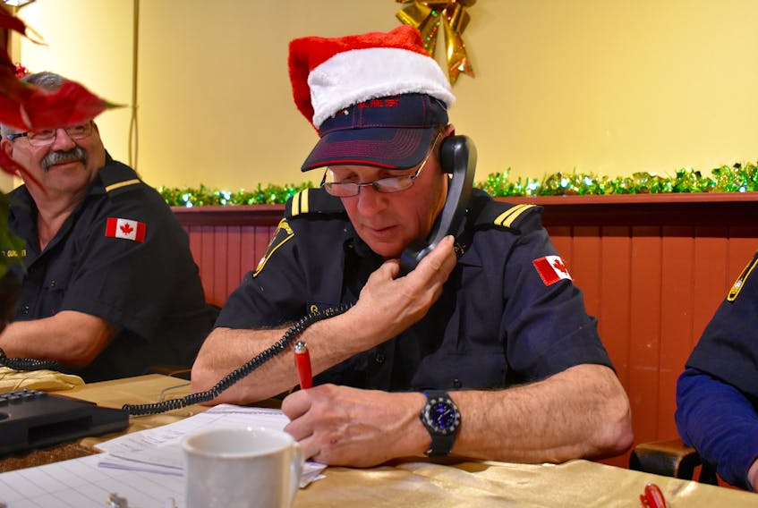 Gerald Coady of the New Waterford Volunteer Fire Department is seen collecting pledges during the annual Combined Christmas Giving Telethon and Auction in New Waterford, Saturday. The local fire department has been helping with the telethon and auction for many years.