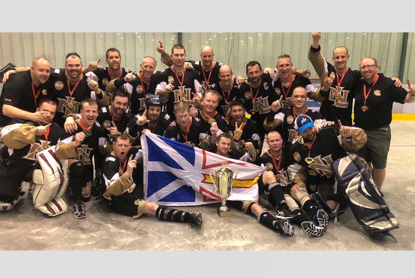 Members of the Colonial Auto Parts team from St. John’s celebrate with their gold medals and championship trophy after winning the Canadian masters men’s ball hockey championship Saturday in Winnipeg. — Submitted/Twitter