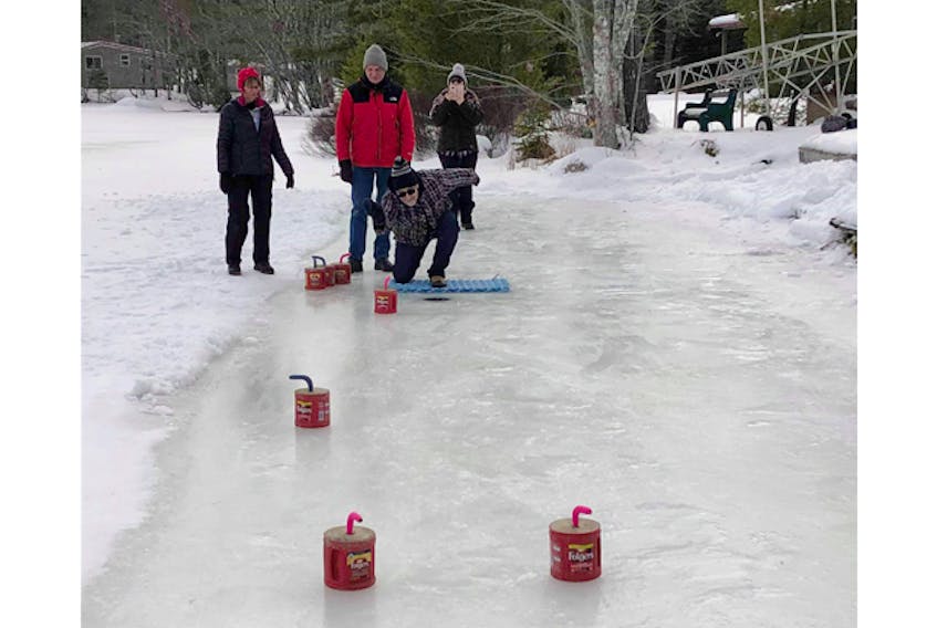 Looking on left to right: Robin Bradshaw; Norm Wredenhagen; Karen Reid; 
Curler: Lorne Reid, coming out of the Lobster Rope Hack, (homemade right here in Nova Scotia). Apparently good on ice as well as your back door.