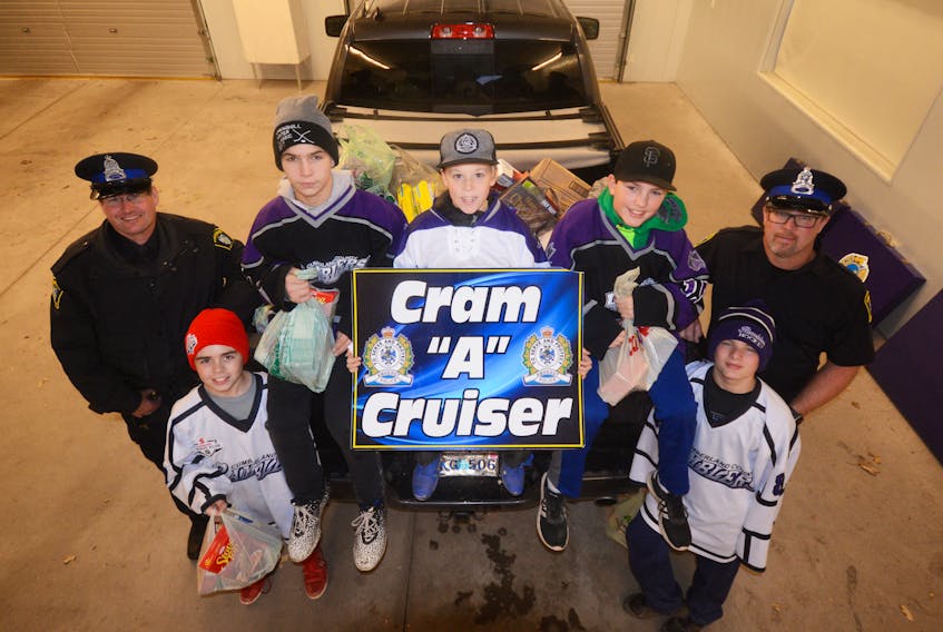 Amherst Peewee AAA Ramblers hockey players loaded the back of this pickup truck with food, and then unloaded it at the Amherst Food Bank. Players helping Const. Tom Wood, left, and Const. Tim Hunter with the Amherst Police Department’s 2018 Cram-A-Cruiser campaign are: (from left) Sawyer Harvey, Kieran Sears, Lucas Hurley, Phoenix Remington and Connor Hunter.