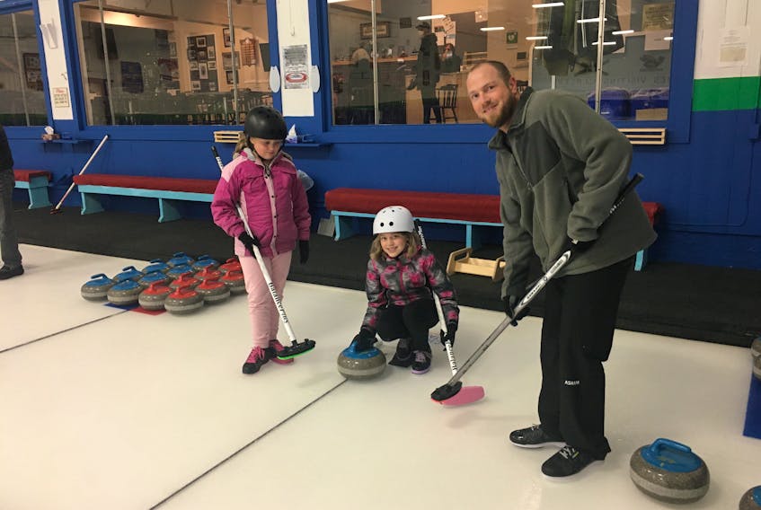 Amherst curler member Jeff MacDonald and his daughters Danielle, 11, and Emily, 10, get prepared to throw a stone at the Amherst Curling Club. The 2020-21 season is opening with an open house on Thursday and Friday night from 6:30 to 8:30 p.m.