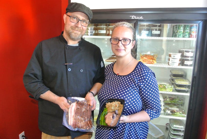 Dan Corbett and Elizabeth Solloway show off just a couple of items from the menu at D&E’s Smoked Meats, Kitchen and Catering Services in Brookdale, just outside Amherst. The couple opened their kitchen and catering service at 502 Willow St. in late October and business has been booming ever since.