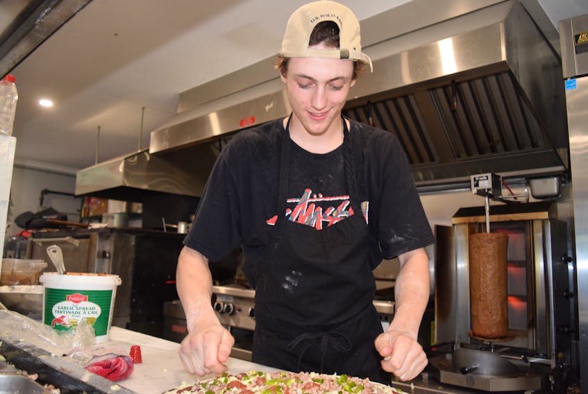Chef Chance Johnson at the Willow Street Pizza and Diner restaurant takes genuine pride in his creations. Placing toppings on pizza and prepping donair meat slices is all in a day’s work for him.