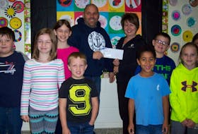 Accepting the $500 cheque for the school breakfast program from Évangéline-Central Credit Union representative, Joan St. John, are students from the Ellerslie school and their principal Jason Cormier.