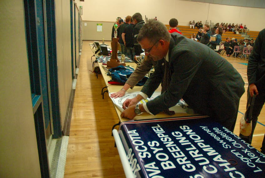 Frank Grant (foreground), director of Yarmouth Recreation, helps get things ready for a past Yarmouth County athletic awards ceremony at the Par-en-Bas school in Tusket. This year's ceremony -- also to be held at Par-en-Bas -- is scheduled for Nov. 30.