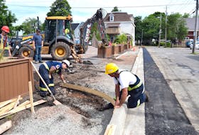 A public works crew in Truro are in the process of constructing a new sidewalk on Revere Street, as part of a number of ongoing street projects throughout town. Seen above from left are: Bernie Wallace, machine operator Jason Cavanagh, Darryl Steele and Jim Cumming.