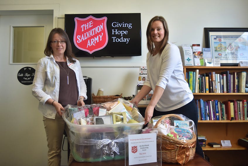 Salvation Army employees Wendy Ward and Rebecca Ervin display some of the baskets that will be part of the silent and live auction held on May 29 for Red Shield Night, a fundraiser for the Salvation Army.