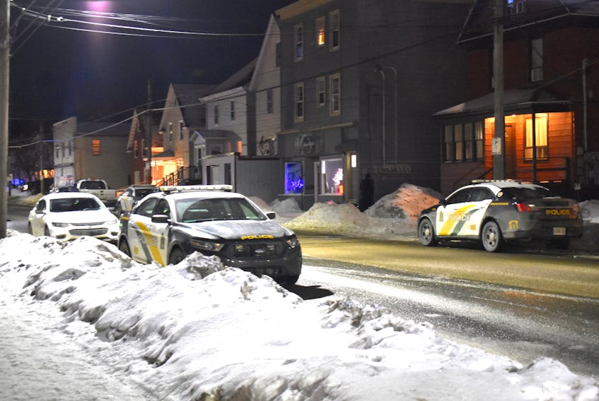 A Cape Breton Regional Police officer, middle, is seen at the corner of building on Townsend Street in Sydney Tuesday evening. About 10 police vehicles as well as the K-9 unit are currently on scene near civic address 280. Regional Police could not be reached for comment as of 6:15 p.m.