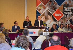 Nova Scotia Nurses Union president Janet Hazelton is seen sharing the microphone with Health and Wellness Minister Randy Delorey during the union's annual conference in Truro on Monday.