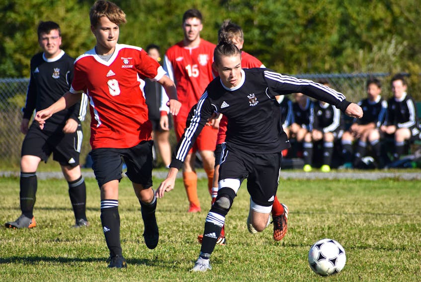 Daniel Nemis of the Breton Education Centre Bears, right, prepares to take a shot on goal as he's pressured by Ben MacDonald of the Riverview Reds junior varsity team during Cape Breton High School Soccer League boys action at Riverview High School on Friday. BEC won the game 10-1.