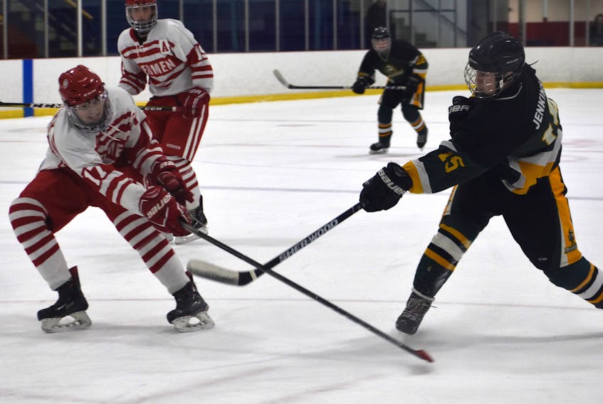 Ian Jenkins of the Memorial Marauders, right, fires a shot on goal as Ethan Stanwick of the Riverivew Redmen attempts to get a stick on it during Cape Breton High School Hockey League action at the Cape Breton County Recreation Centre on Friday. Riverview won the game 3-2 in overtime.