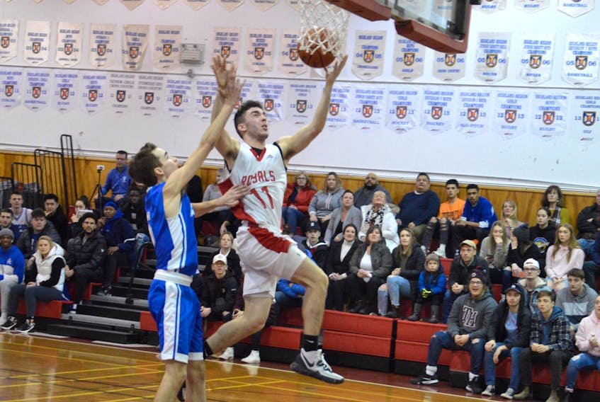 Dylan Quirk of the Riverview Redmen, right, goes for a layup as he's pressured by Justin Pace of the Sydney Academy Wildcats during Cape Breton High School Basketball League playoff action at Riverview High School on Thursday. Riverview won the game 82-78.