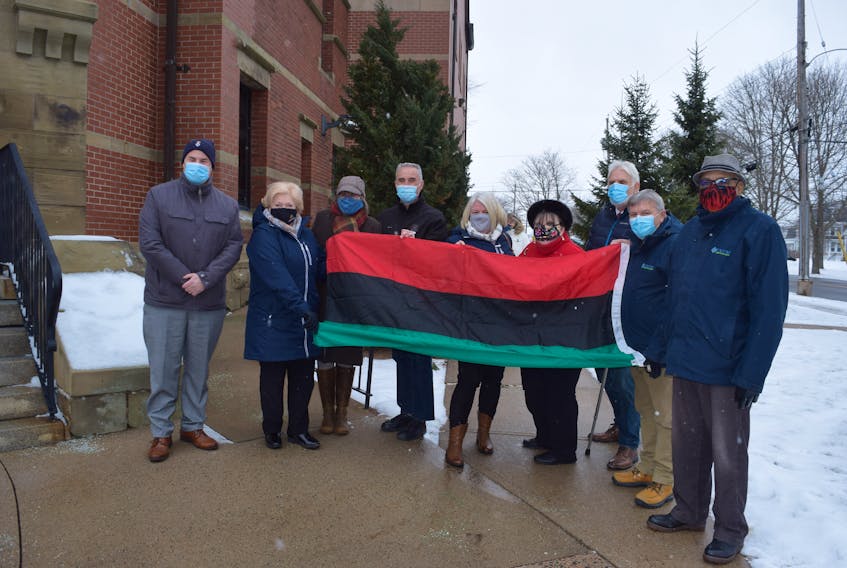 Town and county representatives gather around the Pan-African flag.