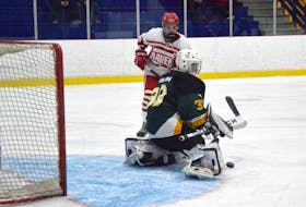Andrew Marsh of the Memorial Marauders makes a right pad save as Liam Brann of the Riverview Ravens watches at the top of the crease during Cape Breton High School Hockey League action at the Cape Breton County Recreation Centre in Coxheath on Friday. Riverview won the game 8-4.