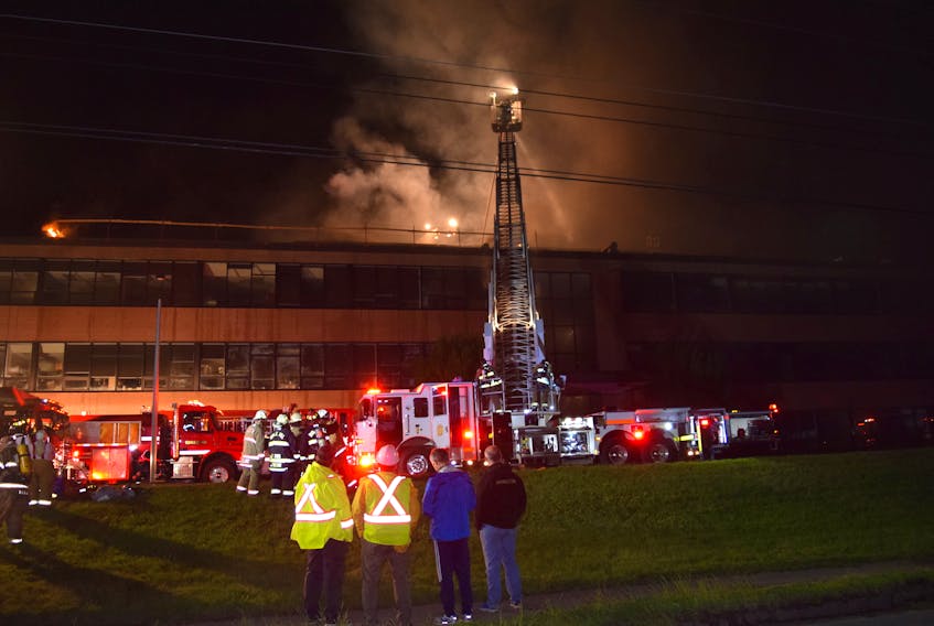 Dr. David Gray, at right, principal of the Dalhousie Agriculture Campus in Bible Hill, watches as fire fighters from various area department battle a blaze that broke out on the roof of the Cox Institute building Wednesday night. Fire fighters battled the blaze into the early morning hours.