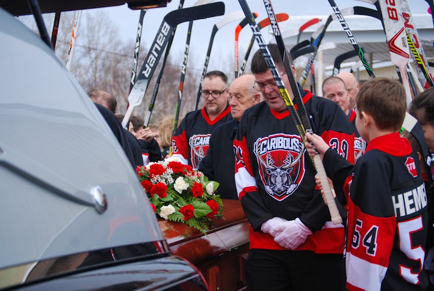 With raised hockey sticks and wearing the Caribous colours, teammates and coaches said their final good-bye today, Dec. 30, to Joshua Wilcox.