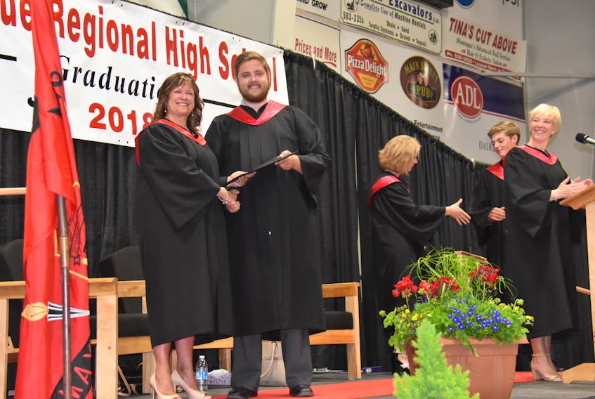 Justin McCarthy accepts his twin brother's Montague Regional High School graduation certificate from principal Seana Evans-Renuad to a standing ovation at the Cavendish Farms Wellness Centre on Thursday. Justin's brother Brodie McCarthy died in Summerside on May 13 following a rugby injury two days earlier. Justin played on the same team and accompanied Brodie to the Prince County Hospital before Brodie was transferred to Moncton for a surgery that was ultimately unsuccessful.