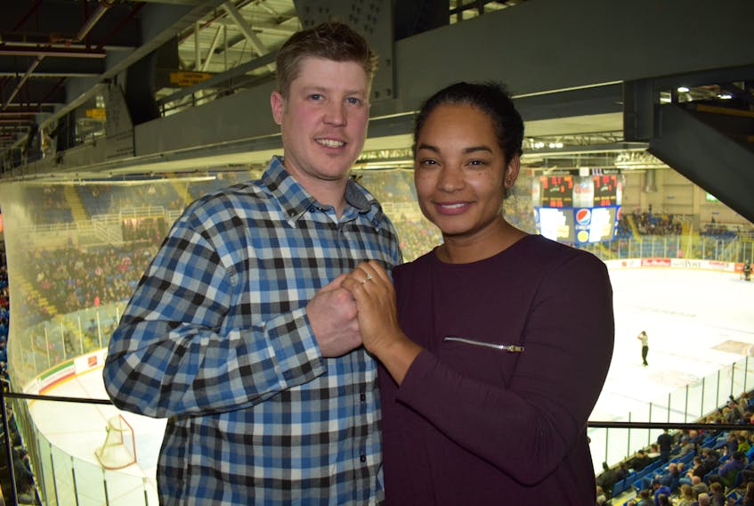 Lee Crawley, left, and Tamara Alleyne hold hands as the Cape Breton Eagles and Halifax Mooseheads play in the background. Crawley proposed to Alleyne during a stoppage in play in the first period of the Quebec Major Junior Hockey League game at Centre 200 on Friday. Alleyne said yes.