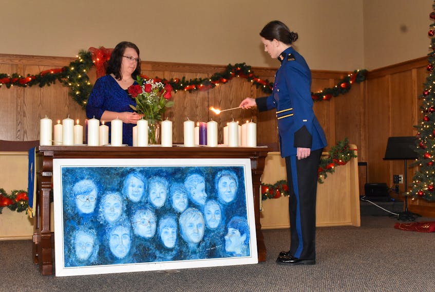 Cst. Lorna DeWare lights a candle for one of the victims of a mass shooting at Ecole Polytechnique in Montreal 30 years ago.
