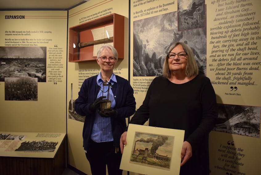 Museum of Industry director Debra McNabb and Pictou County historian Judith Hoegg Ryan inside the Nova Scotia Coal Mine Tragedies exhibit. On June 10 the exhibit's online content will be launched; a database containing the names and dates of 2500 coal miners who lost their lives working in Nova Scotia.