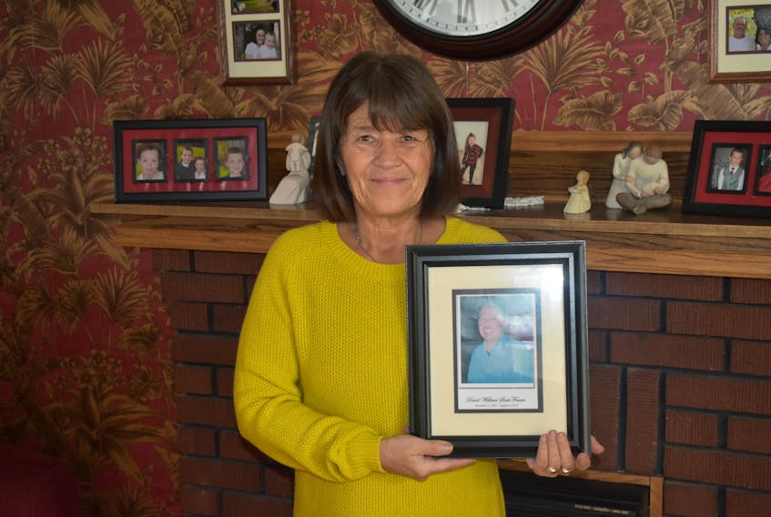 Kathy MacNaughton holds a picture of her late common-law partner David Fraser. Because of his experience, she’s made it her goal to fight for more access to EI for Canadians who are ill.