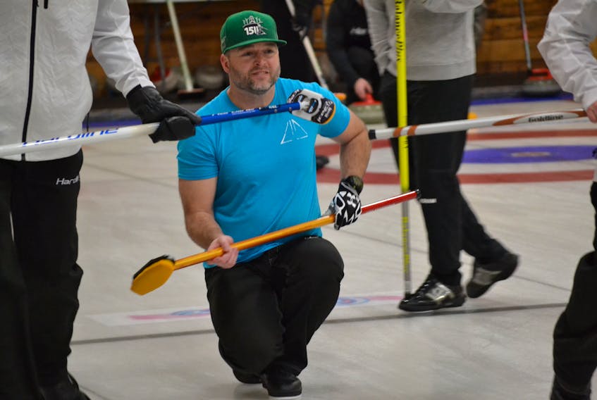 Mike Spencer, second stone for Darren Higgins Silver Fox rink, appears fenced in with curling brooms as he releases a rock during P.E.I. Tankard provincial men's curling championship action at the Western Community Curling Club. Higgins won an elimination game 10-4 over club mate Jamie Newson Friday. He plays Tyler Smith in Saturday's 9 a.m. draw.