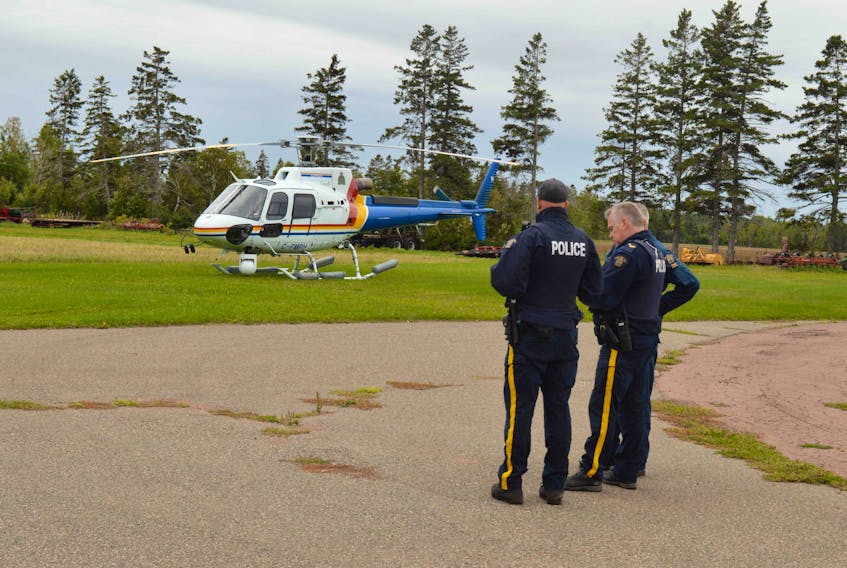 Members of the RCMP discuss the search for two missing boys near Fox Island Friday.