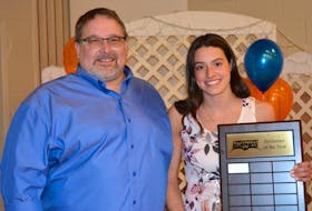Charlottetown Bluephins head coach Tom Ponting presents Alexa McQuaid with her plaque after she was named the club’s swimmer of the year.