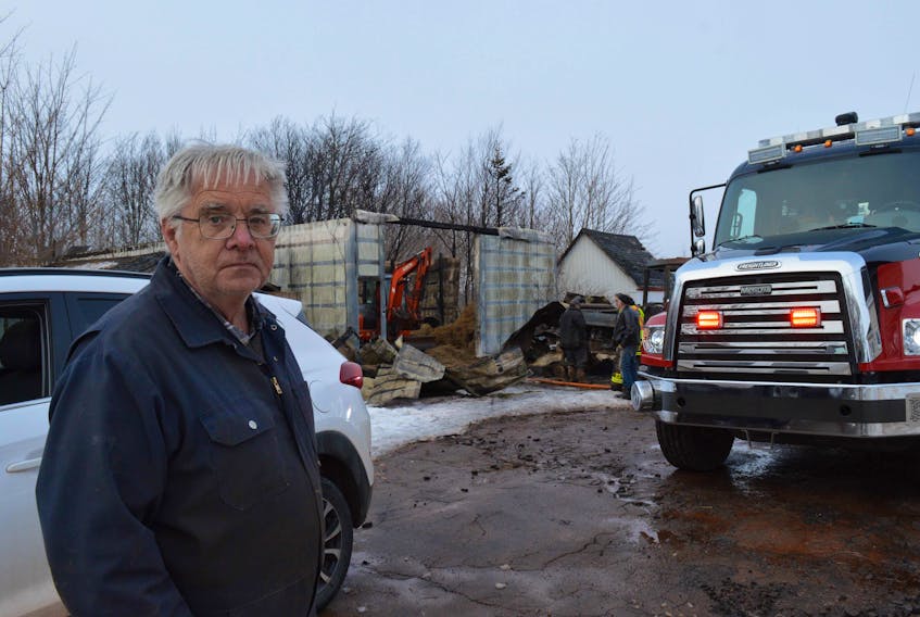 Farmer Leonard Malone stands in front of his destroyed barn. He had just put away his tractor and gone for the mail when the fire broke out 9:30 Wednesday morning. None of his beef cattle were harmed.