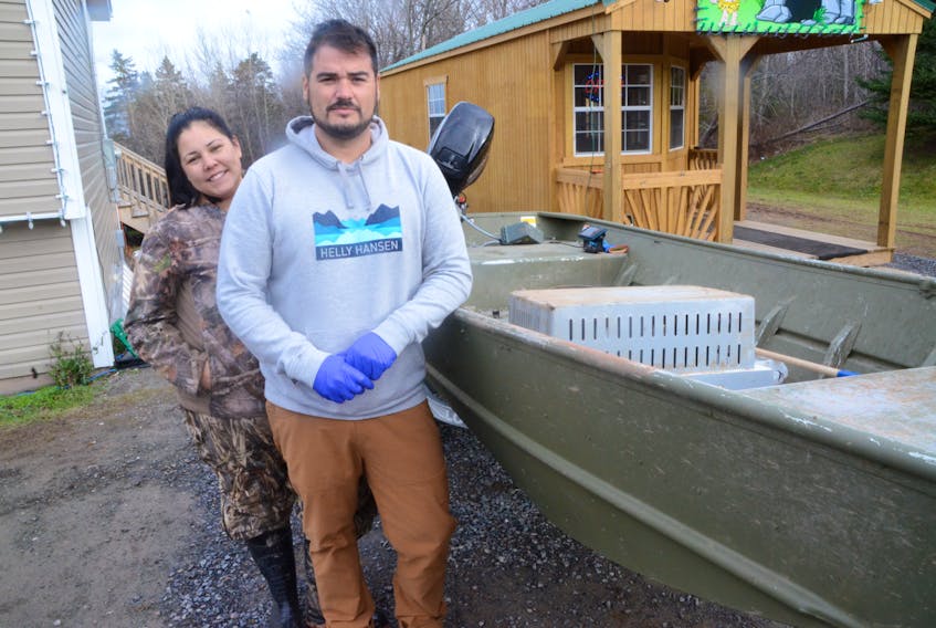 Sylvia Bernard and Gary Denny with the aluminum boat from which the couple fishes their moderate livelihood licenses. Shots were fired toward the boat from a larger vessel that Denny caught hauling his gear on Sunday.
