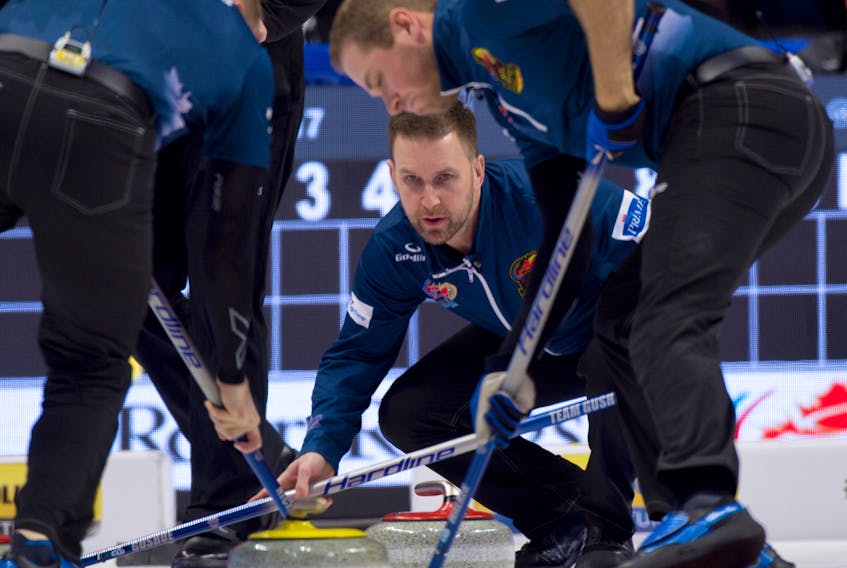 Michael Burns/Curling Canada Skip Brad Gushue encourages his sweepers, from left Mark Nichols and Geoff Walker, during his final round-robin game at the Canadian Olympic Curling Trials Friday night in Ottawa. Team Gushue beat Kevin Koe's team 6-3.