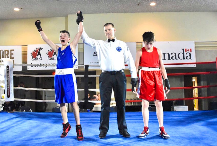 Newfoundland's Carter Butler (left) is announced as Canadian junior champion in the 46-kilogram division at the Canadiaan boxing championships in Edmonton. Butler defeated Ontario's Dennis Mirsoane (right) in a split decision. — Boxing Canada/Twitter