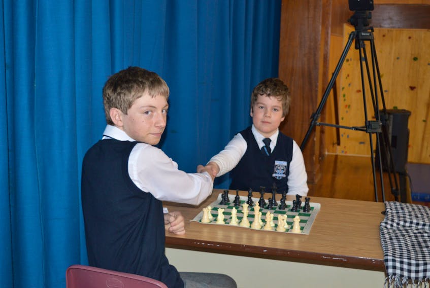 Level I student, Daley Merrigan (left), poses with grade three student, Noah Wall (right), before beginning to play a game of chess. Daley played blindfolded with the verbal assistance of a teacher. Daley will compete on Sunday at the National Chess Championship in St. John's.