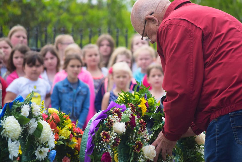 Allen Martin lays a wreath on behalf of the Westray Families Group during a Davis Day ceremony held in Stellarton on Monday.