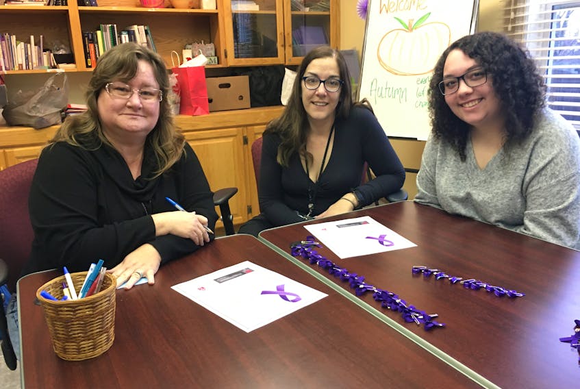 Autumn House executive director Dawn Ferris, Lisa George and NSCC student Bethany Woodland prepare items for the National Day of Remembrance and Action on Violence Against Women at the Community Credit Union Business Innovation Centre on Friday, Dec. 6 from noon to 1 p.m.