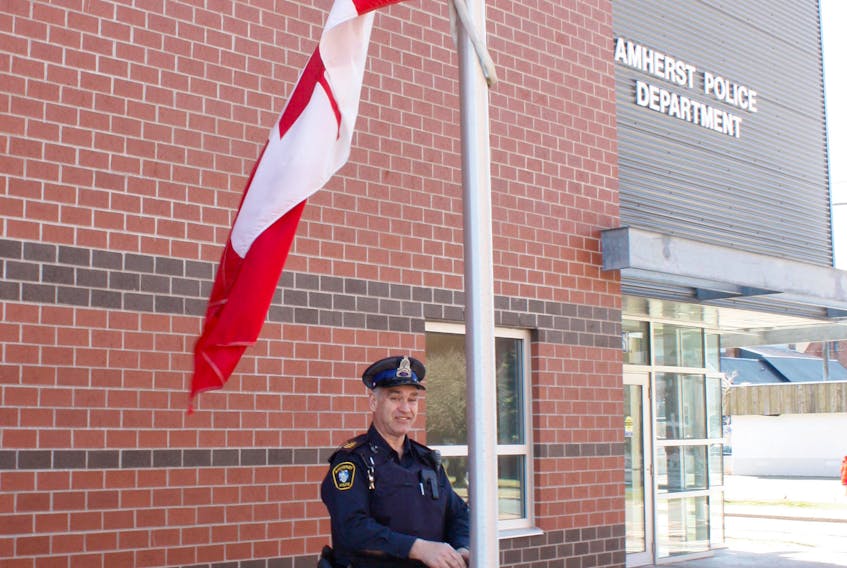 SSgt. Scott White lowered the flag in front of the Amherst Police station to half-mast on April 27 in recognition of the National Day of Mourning